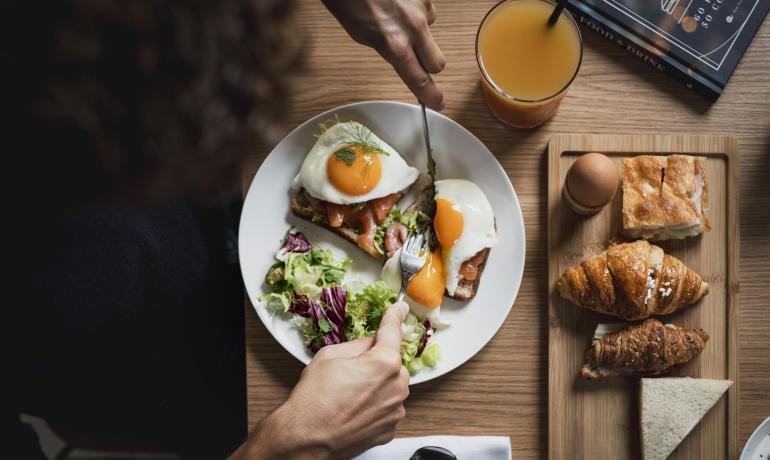 Frühstück mit Eiern, Salat, Croissants und Orangensaft.